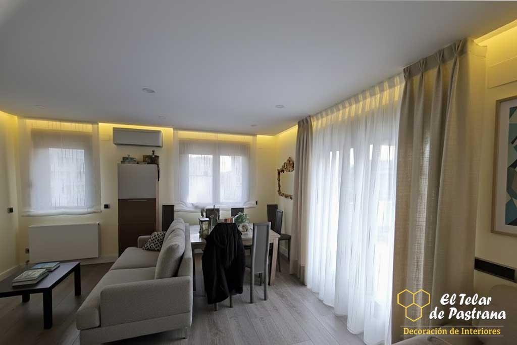 alón moderno y luminoso con suelo de madera, sofá gris y cortinas largas en color beige y blanco instaladas con pinza pliegue.