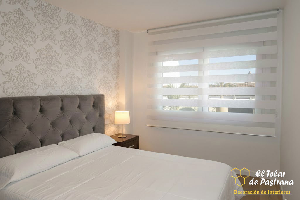 Dormitorio principal con estor noche y día blanco instalado en ventana, regulando la entrada de luz natural y aportando privacidad