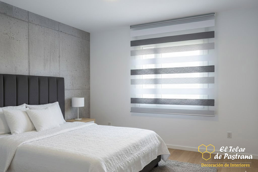 Dormitorio moderno con estor noche y día en tonos gris y blanco instalado en ventana, regulando la luz natural y aportando privacidad