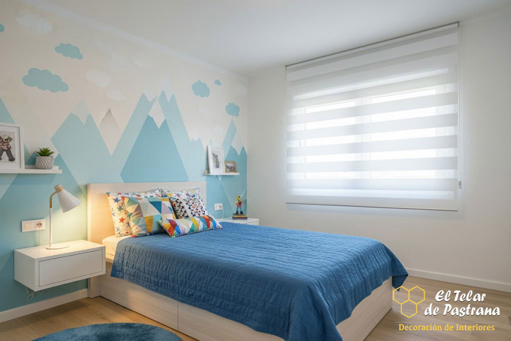 Dormitorio infantil luminoso con estor noche y día blanco instalado en ventana, decoración en tonos azules y control suave de la luz natural