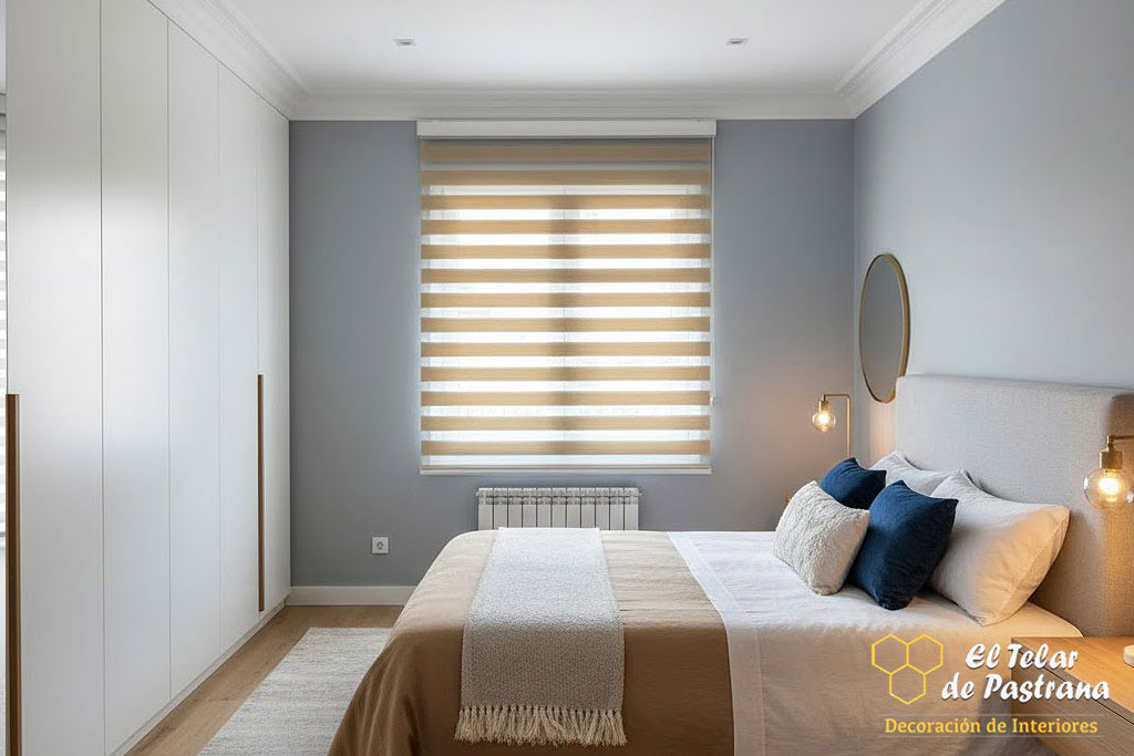 Dormitorio principal moderno con estor noche y día en tono beige instalado en ventana, aportando control de luz y una estética cálida y elegante