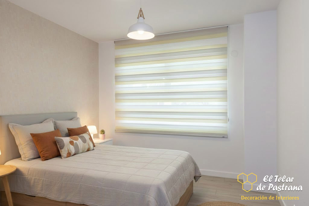 Dormitorio moderno con estor noche y día en tono beige instalado en ventana, ambiente luminoso y control equilibrado de la luz natural