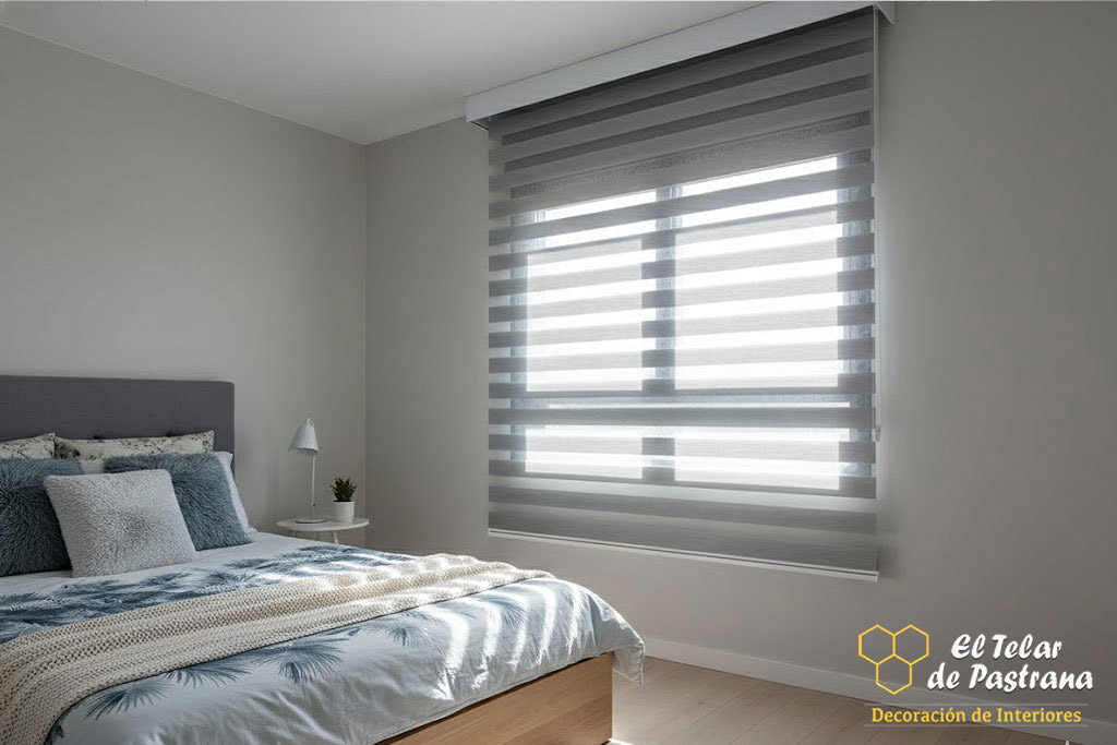 Dormitorio moderno con estor noche y día en tono gris claro instalado en ventana, ambiente sereno y control suave de la luz natural