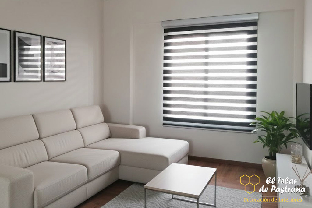 Salón moderno con estor noche y día en tonos gris y blanco instalado en ventana, sofá chaise longue y control de la luz natural