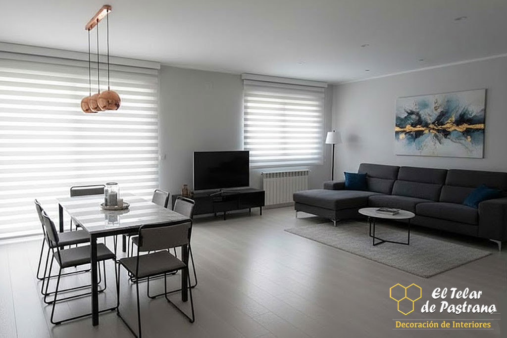 Salón comedor moderno con estores noche y día blancos instalados en grandes ventanas, mesa de comedor, sofá gris y control de luz natural