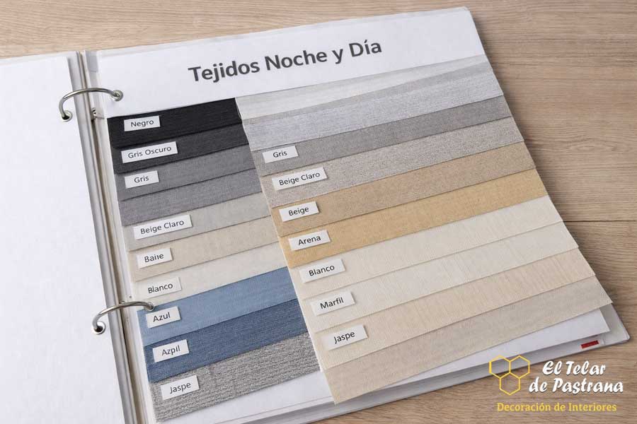 Muestrario de tejidos para estores noche y día con diferentes colores y transparencias, organizado en catálogo de muestras
