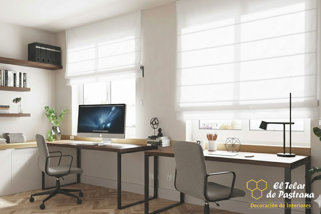 Zona de trabajo en casa con dos escritorios junto a ventanas, estores plegables blancos y mobiliario moderno en tonos claros