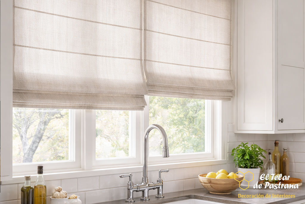 Detalle de estores plegables de lino en color beige instalados sobre la zona de fregadero en cocina con luz natural
